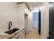 Mudroom area features sink with marble countertops and white cabinets at 9238 E Palm Tree Dr, Scottsdale, AZ 85255