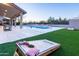 Backyard featuring a pool, covered patio, and cornhole setup on artificial grass at 9238 E Palm Tree Dr, Scottsdale, AZ 85255