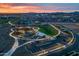 Features an aerial view of a community park with playground, green spaces, parking, and mountain views during a vibrant sunset at 9718 E Radioactive Dr, Mesa, AZ 85212