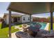 Relaxing backyard features covered patio, pool, artificial grass, and outdoor seating area at 9718 E Radioactive Dr, Mesa, AZ 85212
