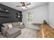 Comfortable bedroom with a wood accent wall, ceiling fan, and built-in desk under a bright window at 9718 E Radioactive Dr, Mesa, AZ 85212