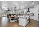 Open-concept kitchen features white cabinets, stainless appliances, and a large island with a farmhouse sink and views to the Gathering room at 9718 E Radioactive Dr, Mesa, AZ 85212