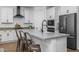 Modern kitchen features a large island with bar seating, stainless steel appliances, and white cabinets at 9718 E Radioactive Dr, Mesa, AZ 85212
