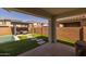 Covered patio leads to a backyard oasis with a pool, seating area, and artificial grass at 9718 E Radioactive Dr, Mesa, AZ 85212
