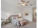 Bright bedroom featuring a ceiling fan, floral bedding, neutral walls, and two pink ottomans at 9738 E Tiburon Ave, Mesa, AZ 85212
