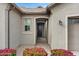 Inviting front entrance with manicured flower beds, an arched entryway, and a dark wood front door at 9738 E Tiburon Ave, Mesa, AZ 85212