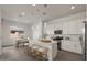 Bright kitchen with white cabinets, stainless steel appliances, island with seating, and adjacent dining area at 9738 E Tiburon Ave, Mesa, AZ 85212