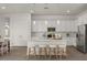 Modern kitchen features white cabinetry, stainless appliances, and an island with bar stool seating at 9738 E Tiburon Ave, Mesa, AZ 85212