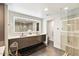 Modern bathroom featuring dual sinks, a large, illuminated mirror, and a sleek glass-enclosed shower for a spa-like feel at 1040 E Osborn Rd # 203, Phoenix, AZ 85014