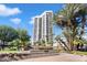 Striking exterior view of the high-rise condo building, surrounded by lush greenery and a beautiful blue sky at 1040 E Osborn Rd # 203, Phoenix, AZ 85014