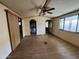 View of the living room with wood-look floors, a ceiling fan, and sliding door access at 10951 N 91St Ave # 206, Peoria, AZ 85345