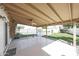 A covered back patio with a ceiling fan overlooks the backyard with the pool beyond the fence and a well-manicured lawn at 11221 N 32Nd St, Phoenix, AZ 85028