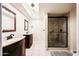 Bathroom showcasing dual sinks with dark cabinetry and a glass enclosed shower at 11221 N 32Nd St, Phoenix, AZ 85028