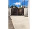 Rustic wooden gate secured between concrete block walls, offering privacy with satellite dish on a concrete surface at 11221 N 32Nd St, Phoenix, AZ 85028