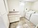 Well lit laundry room features storage cabinets, countertop space, and appliances, blending convenience and practicality at 11221 N 32Nd St, Phoenix, AZ 85028