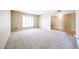 An empty, carpeted living room adjacent to an area with stone tile flooring and a window with plantation shutters at 11221 N 32Nd St, Phoenix, AZ 85028