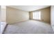 An empty, carpeted living room features a large window with plantation shutters at 11221 N 32Nd St, Phoenix, AZ 85028