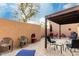 Private patio featuring a mix of brick pavers and concrete, shaded seating, and a mature tree at 11779 E Becker Ln, Scottsdale, AZ 85259