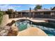 Backyard featuring a custom pool with rock accents and a safety fence, offering serene outdoor enjoyment at 12037 S Bannock St, Phoenix, AZ 85044