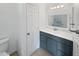 Bright bathroom features a modern blue vanity, well-lit mirror, and a clean, neutral palette at 12037 S Bannock St, Phoenix, AZ 85044