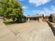 Charming single-story home with a spacious driveway, lush lawn, and mature trees at 12037 S Bannock St, Phoenix, AZ 85044