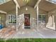 Inviting front entrance with a charming wooden door, columns, and manicured landscaping at 12037 S Bannock St, Phoenix, AZ 85044