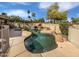 Freeform pool with unique rock features, mature landscaping, and ample deck space for lounging at 12037 S Bannock St, Phoenix, AZ 85044