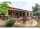 Outdoor patio with dining area, stone bar, fire pit, and lush landscaping at 12572 W Jasmine Trl, Peoria, AZ 85383