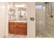 Bathroom vanity with granite counters and tiled walk-in shower with glass doors at 12572 W Jasmine Trl, Peoria, AZ 85383