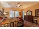 Bedroom featuring a ceiling fan, wood floors, and a stylish quilt on the bed at 12572 W Jasmine Trl, Peoria, AZ 85383