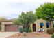 Charming single-story home with a stone facade, mature trees, and desert landscaping at 12572 W Jasmine Trl, Peoria, AZ 85383