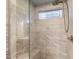 Shower with glass door, window and bench with beautiful marble style tile at 12572 W Jasmine Trl, Peoria, AZ 85383