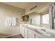 Bathroom featuring double sinks, a large mirror, neutral walls, and a tiled floor at 14406 N 129Th Ave, El Mirage, AZ 85335