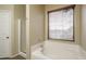 Bathroom featuring a bathtub, shower stall, window with blinds, and neutral colored walls at 14406 N 129Th Ave, El Mirage, AZ 85335