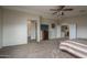 Spacious bedroom featuring neutral walls, ceiling fan, carpet floors, and a doorway to the bathroom at 14406 N 129Th Ave, El Mirage, AZ 85335