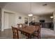 Formal dining area featuring a wooden table with seating for six, tiled floors, and views into the living areas at 14406 N 129Th Ave, El Mirage, AZ 85335