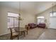 Bright living room featuring high ceilings, large windows, modern chandelier, and plush leather couches at 14406 N 129Th Ave, El Mirage, AZ 85335