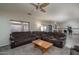 Comfortable living area with a large sectional sofa, ceiling fan, adjacent dining area, and modern lighting at 14406 N 129Th Ave, El Mirage, AZ 85335