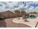 Backyard featuring a pool with a rock waterfall feature, decorative rocks, and lounge chairs at 14406 N 129Th Ave, El Mirage, AZ 85335