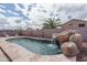 Backyard pool featuring a rock waterfall feature and decorative rocks, surrounded by fencing at 14406 N 129Th Ave, El Mirage, AZ 85335