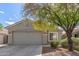 Charming single-story home with a neutral stucco exterior, mature landscaping, and a two-car garage at 14838 N 172Nd Ln, Surprise, AZ 85388