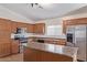 Well-equipped kitchen with stainless steel appliances, wood cabinets, a functional island, and durable countertops at 14838 N 172Nd Ln, Surprise, AZ 85388