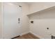 Neutral laundry room with white walls, light wood floors, shelf and white door for efficient storage at 14838 N 172Nd Ln, Surprise, AZ 85388