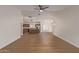 Bright living room boasts wood-look floors, neutral paint, a ceiling fan, and flows into the kitchen and dining spaces at 14838 N 172Nd Ln, Surprise, AZ 85388