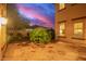 Backyard patio at dusk with decorative tile, a central tree feature, and a view of the house at 15289 W Valentine St, Surprise, AZ 85379