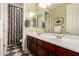 Bathroom with a double sink vanity, checkered floor, and a shower tub combo at 15289 W Valentine St, Surprise, AZ 85379