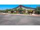 Exterior view of the community clubhouse, featuring a rustic design, landscaped surroundings, and convenient parking at 15289 W Valentine St, Surprise, AZ 85379