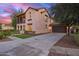 Charming two-story home featuring a front porch, balcony, garage and landscaped front yard at twilight at 15289 W Valentine St, Surprise, AZ 85379