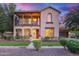 Charming two-story home featuring a front porch, balcony, and landscaped front yard at twilight at 15289 W Valentine St, Surprise, AZ 85379