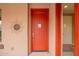 Inviting red front door with metal sun decor and sidelight window at 15289 W Valentine St, Surprise, AZ 85379